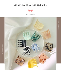 Variety of small acetate butterfly hair claws in marble and floral patterns on silk fabric