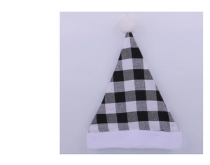Close-up of buffalo plaid Christmas hat with plush white pom-pom and faux fur trim