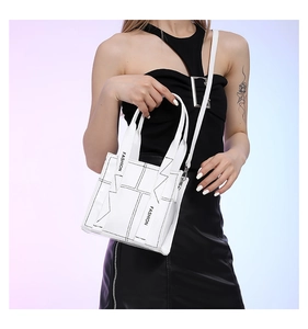 Detail der weißen PU-Handtasche mit schwarzen Kontrastnähten und FASHION-Schriftzug