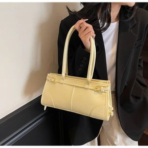 Detailed shot of stylish light yellow PU leather tote bag with elegant gold buckle