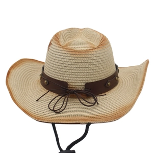 Detail of hand-woven straw cowboy hat featuring ethnic rivets and leather band