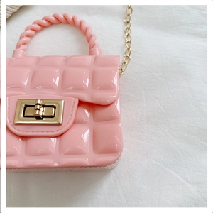Detail of pink quilted jelly bag with glossy PVC texture and golden twist lock