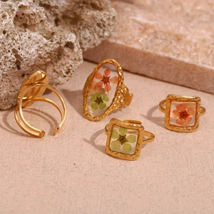 Detail of 18K gold plated hammered rings featuring colorful dried flower resin inserts