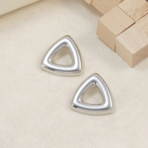 Macro detail of triangular hollow stud earrings with polished silver mirror finish