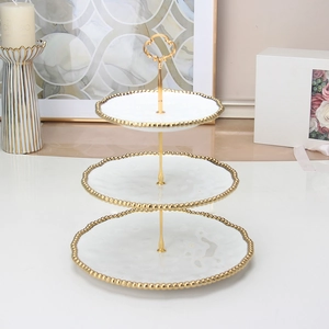 Detailed view of 3-tier white ceramic dessert stand with gold beaded rim and heart handle