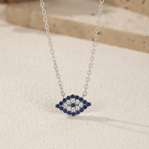 S925 sterling silver evil eye necklace with blue and white zircons on stone surface