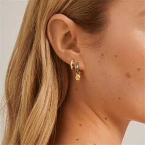 S925 silver hamsa hand earrings with blue and white enamel on a model side profile