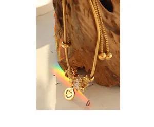 Macro shot of 18K gold plated snake chain bracelet with zircon charms and rainbow lighting