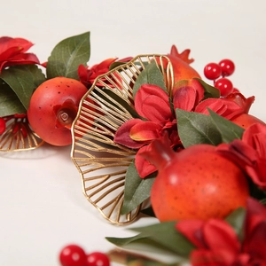 Couronne du Nouvel An avec feuilles dorées, grenades rouges et baies pour décoration