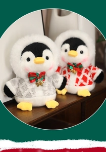 Detail of plush Christmas penguin toys wearing red sweaters and festive golden bells