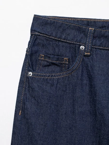Detalle de pantalones vaqueros de talle alto con remaches metálicos y costuras de contraste