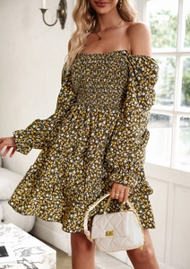 Detail view of floral dark green dress featuring an off-shoulder neckline and ruffled hem