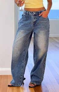 Close-up of vintage washed blue denim fabric and high waist detail on wide leg jeans