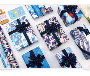 Artistic ocean theme gift wrapping paper with navy blue ribbons and decorative cards