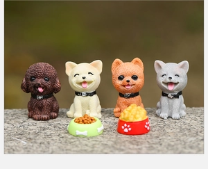 Detail of four miniature resin cartoon dogs and tiny food bowls for garden landscaping