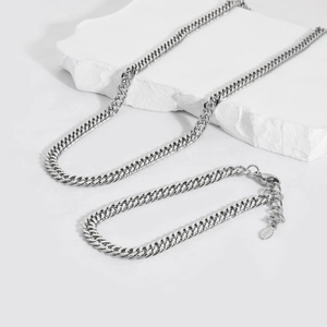 Polished silver 6mm stainless steel Cuban chain necklace and bracelet set on stone decor