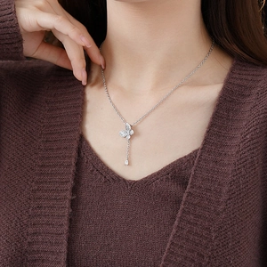 Detail of silver butterfly pendant necklace with sparkling zircon water drop accent