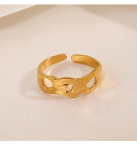 Macro detail of gold-plated stainless steel ring with irregular geometric cutouts