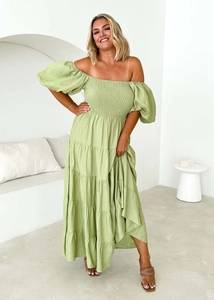 Detailed view of elastic smocked bodice and layered puff sleeves on green maxi dress