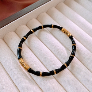 Dettaglio delle giunture del bracciale stile bambù in smalto nero e oro su velluto