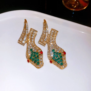 Detailaufnahme von Vintage Schlangenohrringen in Gold mit weißen und grünen Strasssteinen