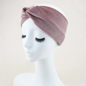 Detail showing the velvet fabric texture and twisted knot design of the pink headband
