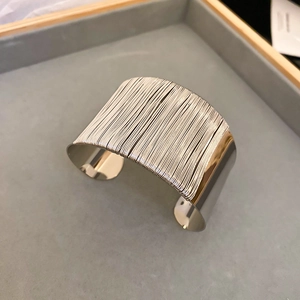 Detailed view of silver twist texture and polished edges on the wide metal bangle