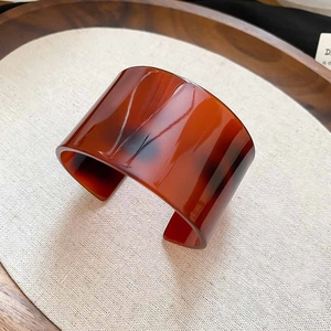 Macro shot of wide acetate resin cuff bangle with tortoiseshell pattern and glossy finish