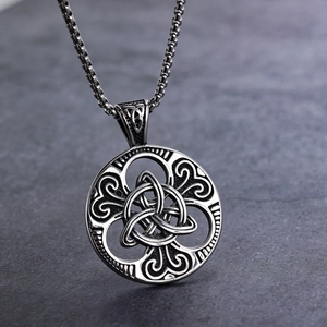 Macro shot of Viking Celtic knot pendant with vintage silver finish on dark rock surface