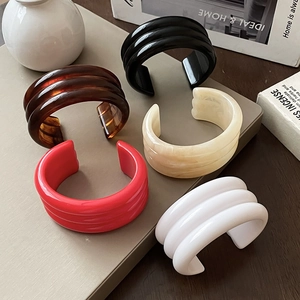 Detail of five-piece chunky resin C-shape cuffs with triple-ribbed texture and marble patterns