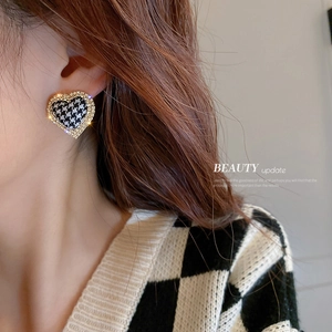 Houndstooth heart earrings with gold trim and rhinestones on a female model side view