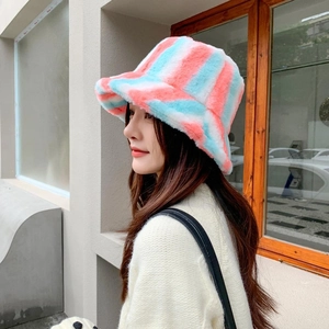 Detail view of a fuzzy plush bucket hat featuring soft pink and light blue stripes
