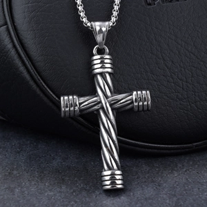 Vintage stainless steel cross pendant necklace with woven design on black leather background