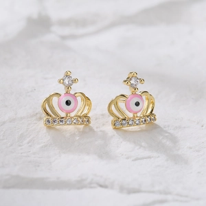 Macro shot of 18K gold plated crown stud earrings with pink evil eye and zircons