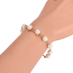 Elegant baroque handmade pearl bracelet with gold metal links on a model wrist