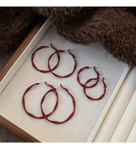 Three pairs of irregular twisted metal hoop earrings in wine red enamel finish