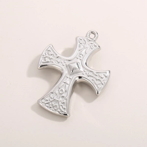 Close-up of silver punk cross pendant with detailed embossed patterns and metal ring