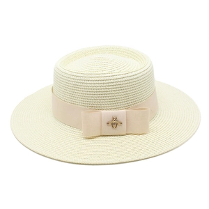 Elegant wide-brimmed cream straw hat featuring a tonal ribbon and golden bee ornament