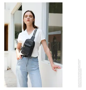 Close-up of stylish checkerboard chest bag with a wide branded shoulder strap on model