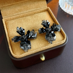 Détail macro de boucles d'oreilles en cristal noir sur une boîte à bijoux en velours