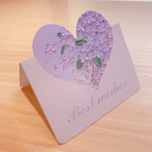 Detailed view of light purple greeting card with heart-shaped floral patterns and Best Wishes text