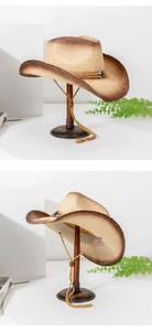Detail view of straw cowboy hat with brown gradient brim and vintage metal buckle decoration