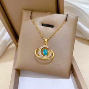 Detail of gold moon and star necklace with blue teardrop stone in a premium gift box