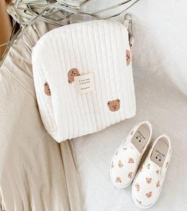 Detailed view of quilted cotton baby bag with bear embroidery and matching printed shoes