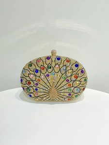Macro shot of colorful rhinestones and crystal peacock pattern on golden clutch bag