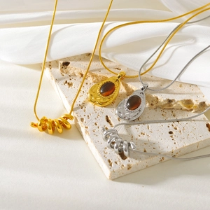 Gold and silver layered necklace set with vintage water-drop gemstones and twisted metal pendants