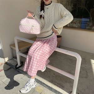 Close-up of pink quilted puffer cosmetic bag with soft handle and metal zipper