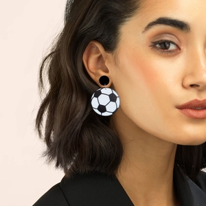 Minimalist black and white football soccer ball earrings worn by female model
