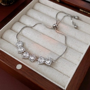 Dettaglio del bracciale regolabile in argento con tre zirconi a cuore scintillanti