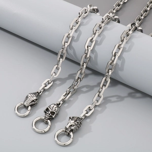 Detail of silver stainless steel chains featuring snake, skull, and lion head charms